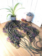Load image into Gallery viewer, lifestyle product photo of an artisan scarf prayer shawl hand felted from merino wool/ tencel blend and a green and purple floral silk chiffon fabric. the felted wool creates soft ruffles in the silk fabric and tussah silk give a lace vibe to the soft and flowing unique piece. there is a small plant and succulent plant along with a white selenite tower lamp and amethyst crystal lamp in the backgound
